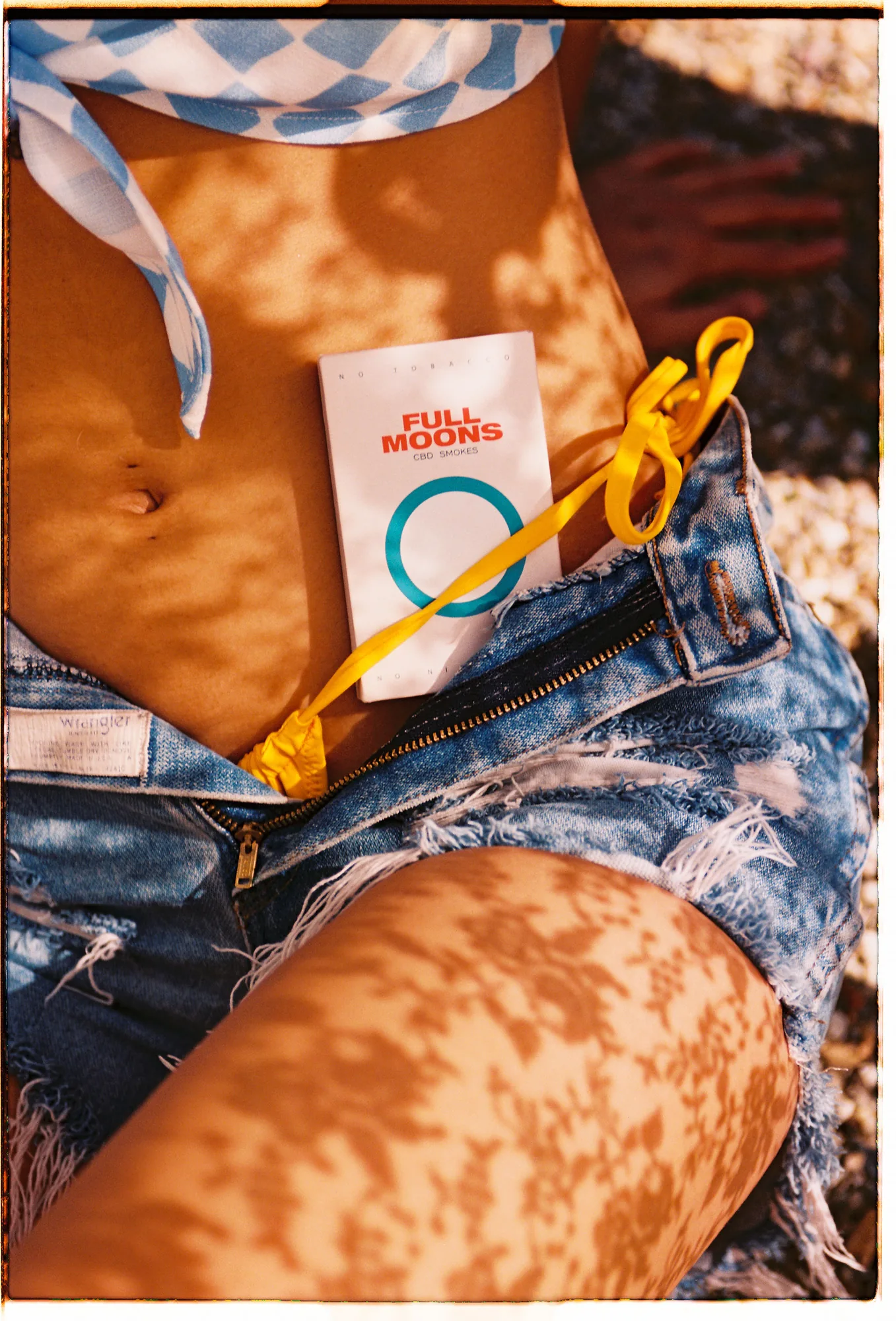 Full Moons pack tucked into denim cutoffs, sun-dappled