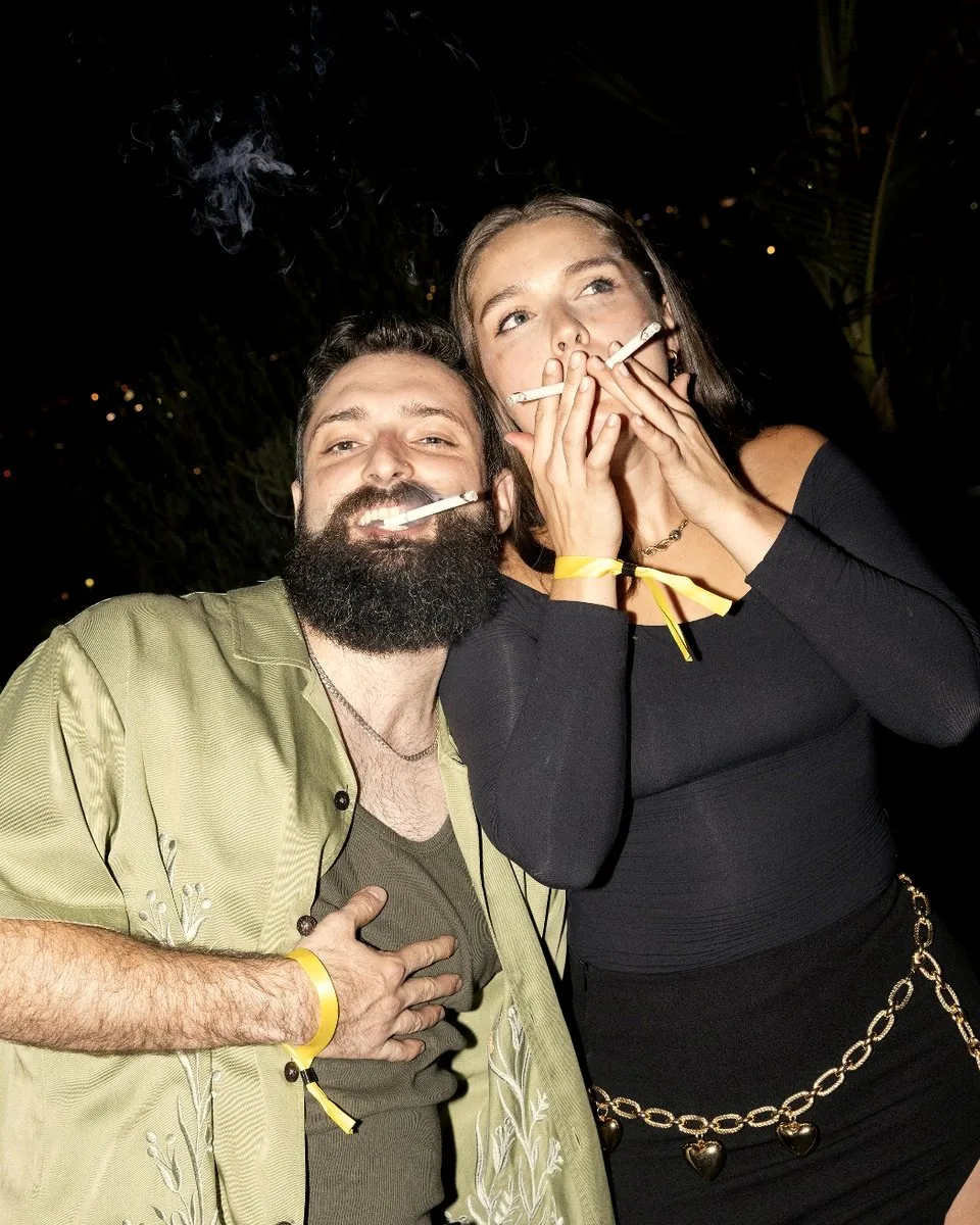 Two friends laughing together at night, each with a Full Moons smoke