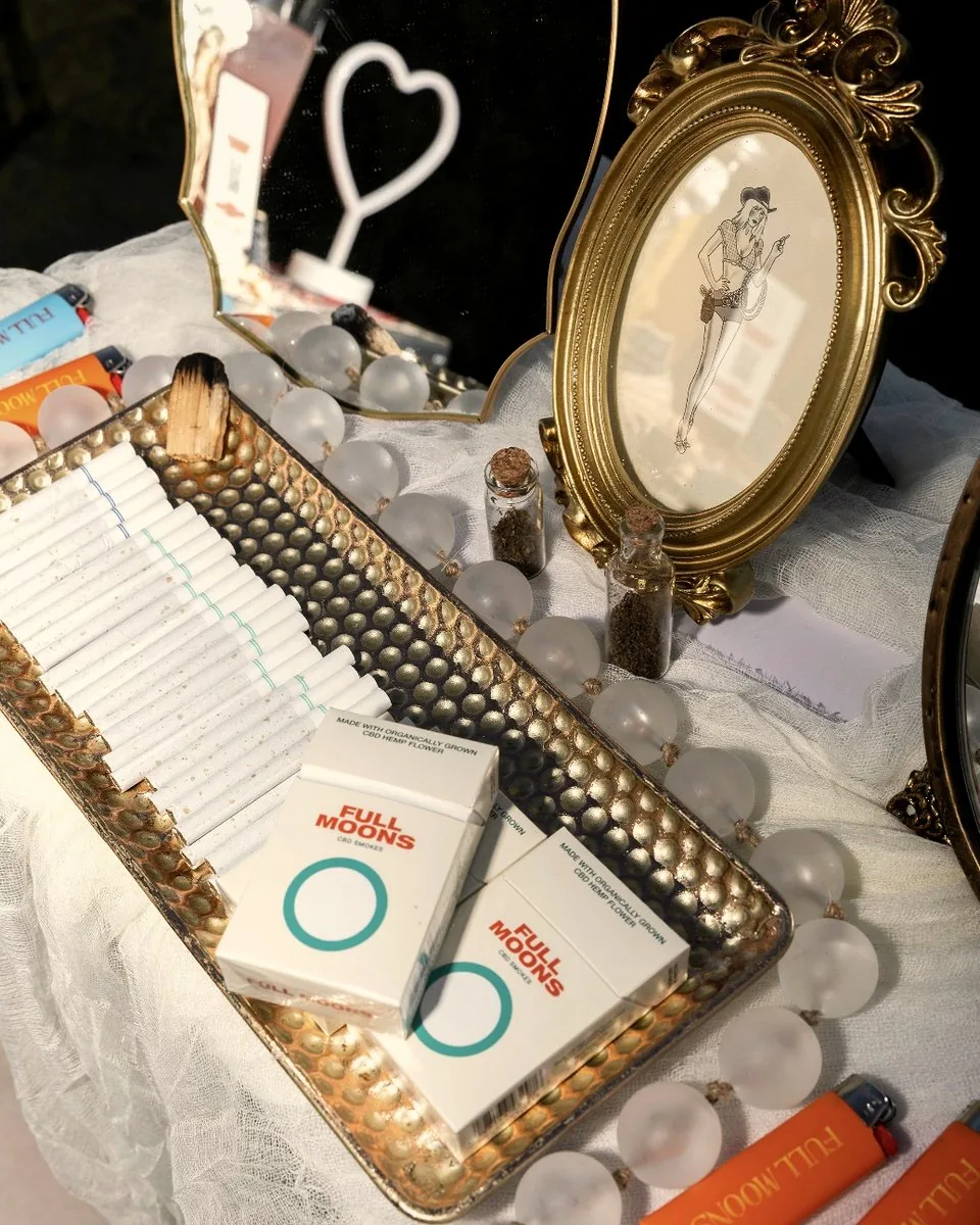 Full Moons packs laid out on a vanity tray with pearls and a gold mirror