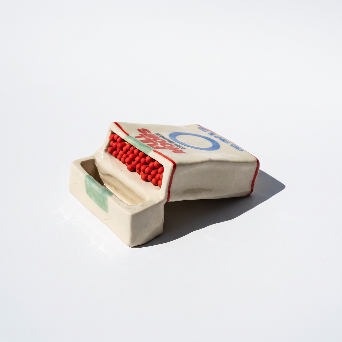 The Memento ceramic matchbox in Original, lying on its side with matches showing